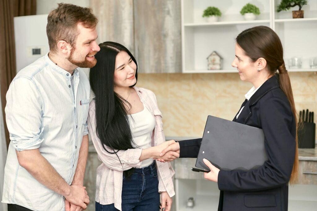 Immobilienmaklerin mit Ehepaar